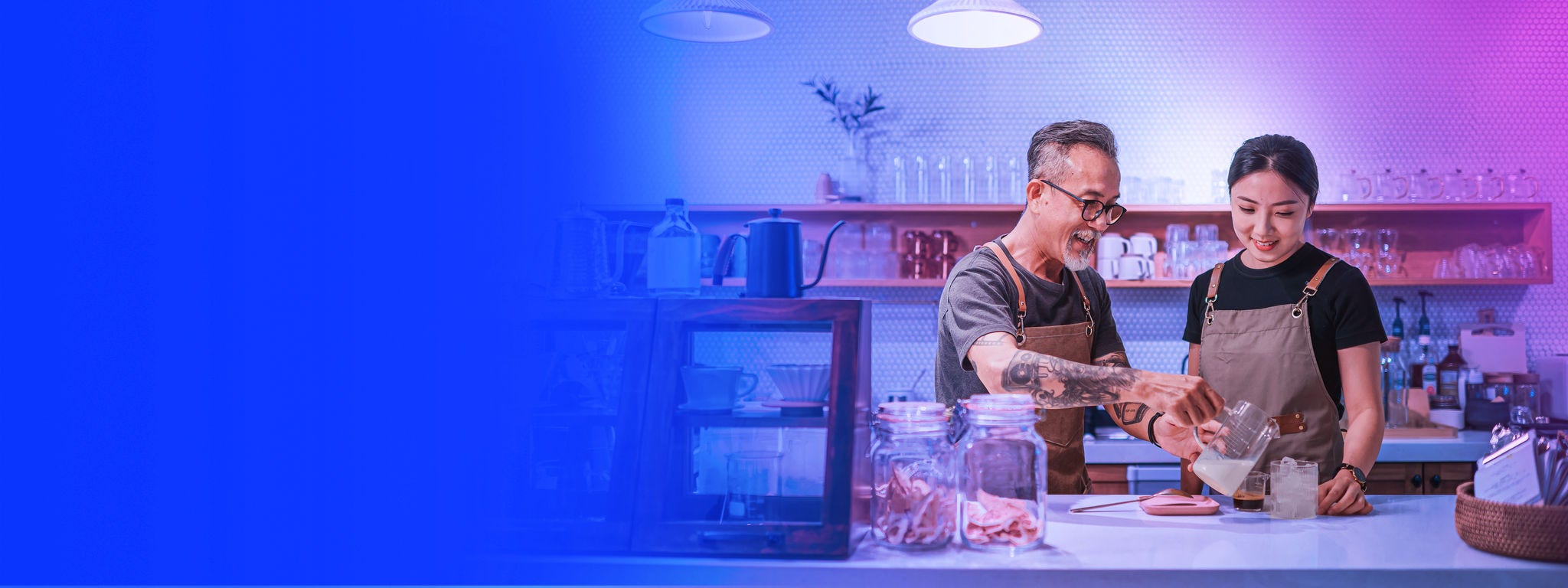 Senior male barista teaching his daughter making coffee at cafe bar counter