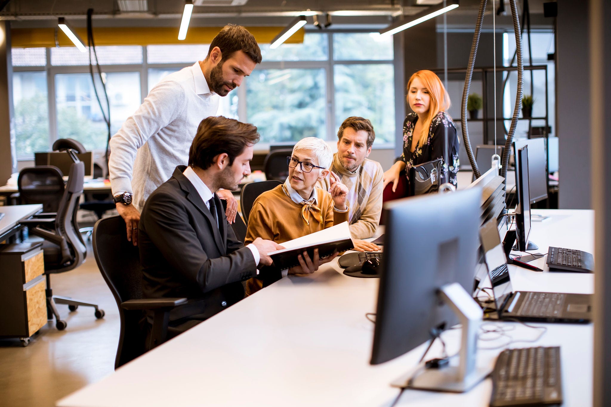 Senior businesswoman working together with young business people in modern office