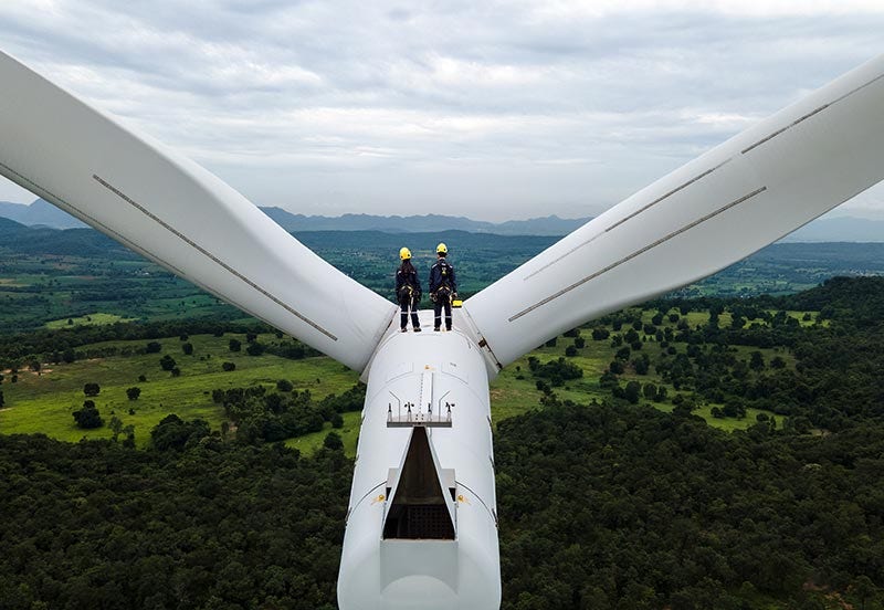IAP energy image Two electrical engineers wearing PPE working on top of wind turbine farm