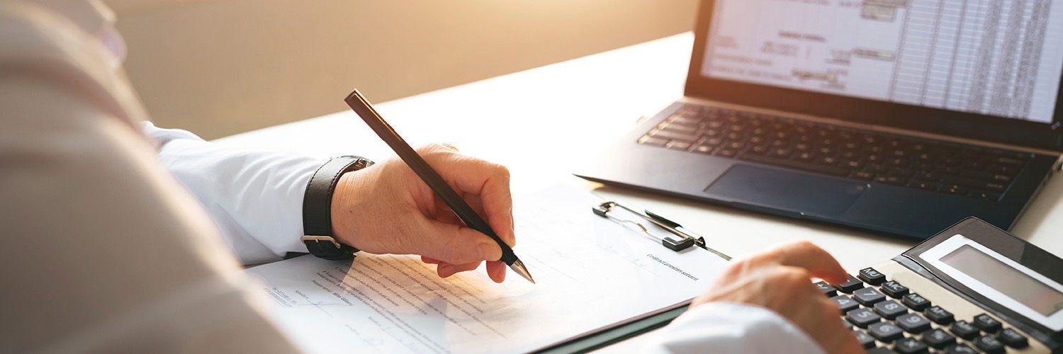 Hand writing with laptop on table