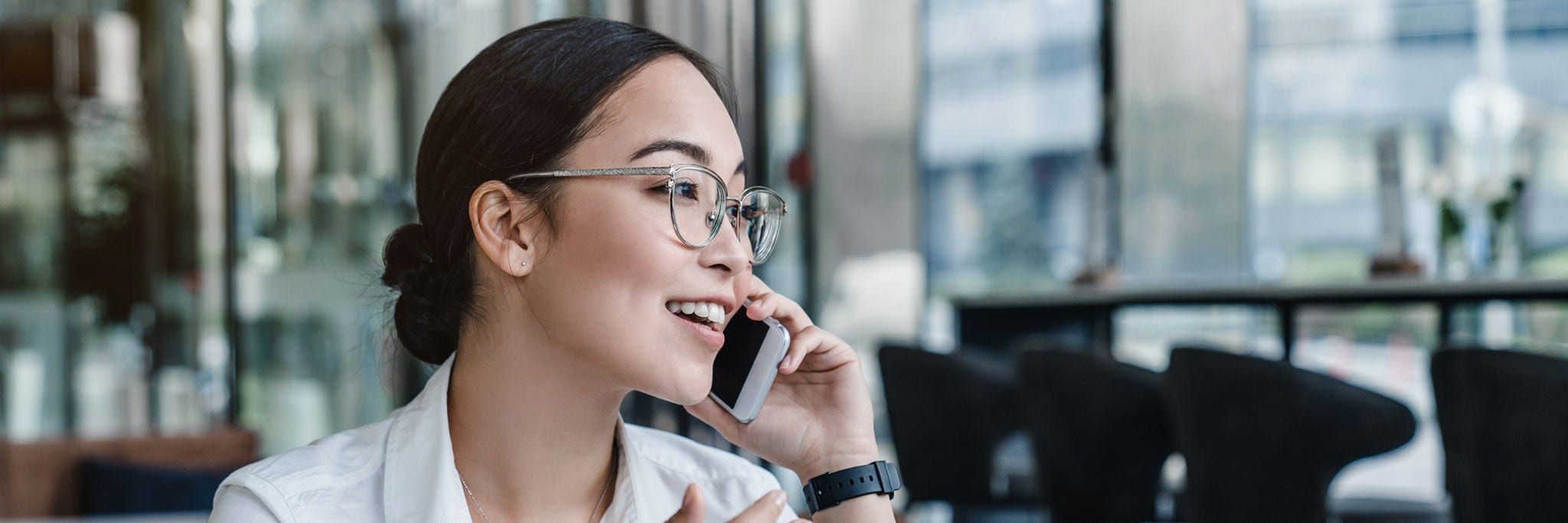 Asian business woman making a phone call and smiling indoor