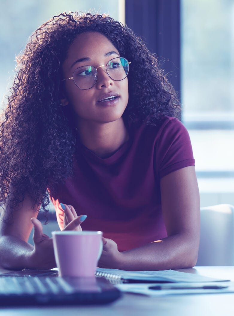 Two women sitting and chatting in a modern office environment.