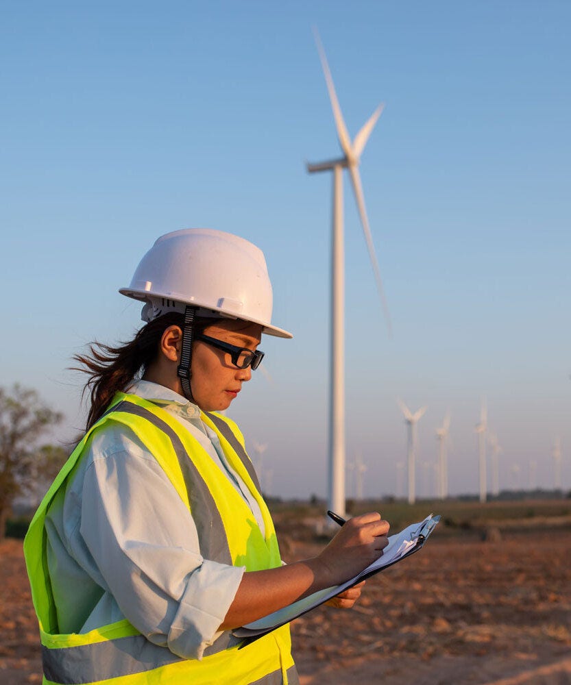 Engineer completing a report at wind turbine farm