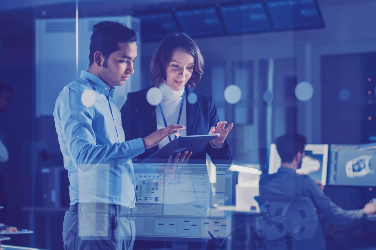 Team analysing data on a digital screen in an office environment.