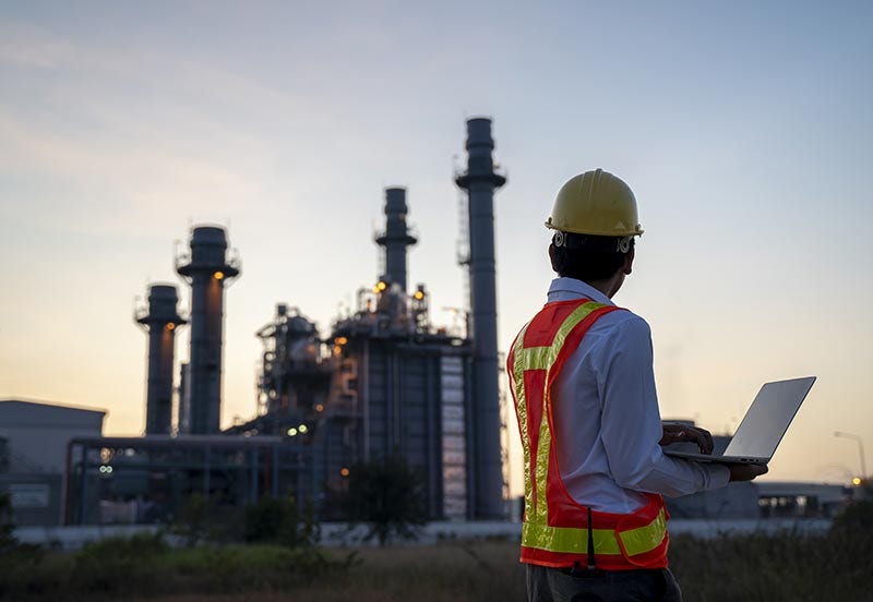 IAP oil and gas image Service engineer working at an electric power plant with laptop