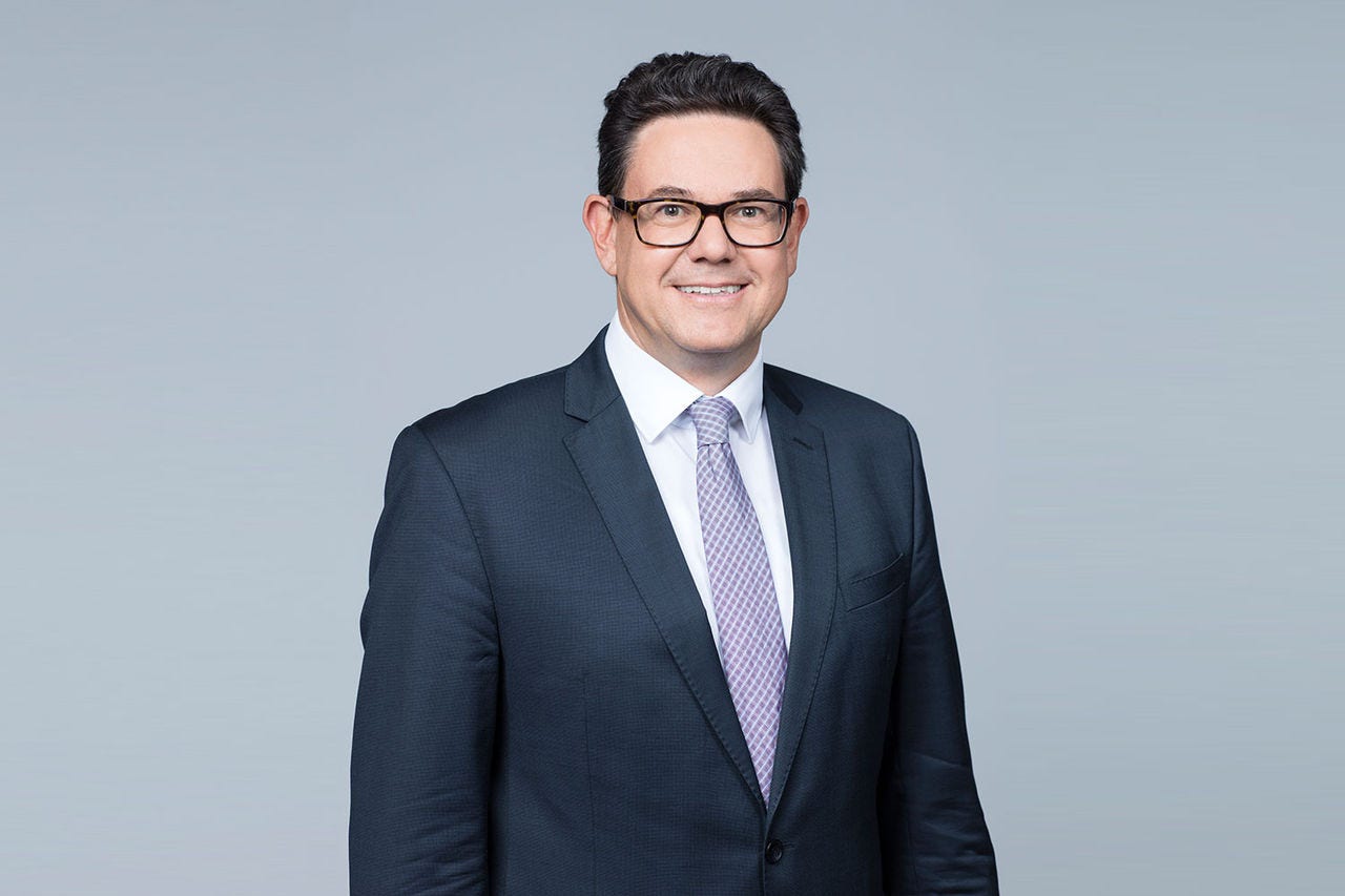 Porträt von Eugen Strimitzer vor einem hellgrauen Hintergrund