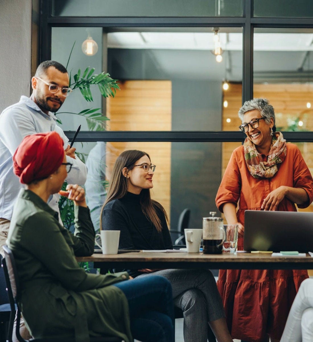 People stood and sat around an office table smiling