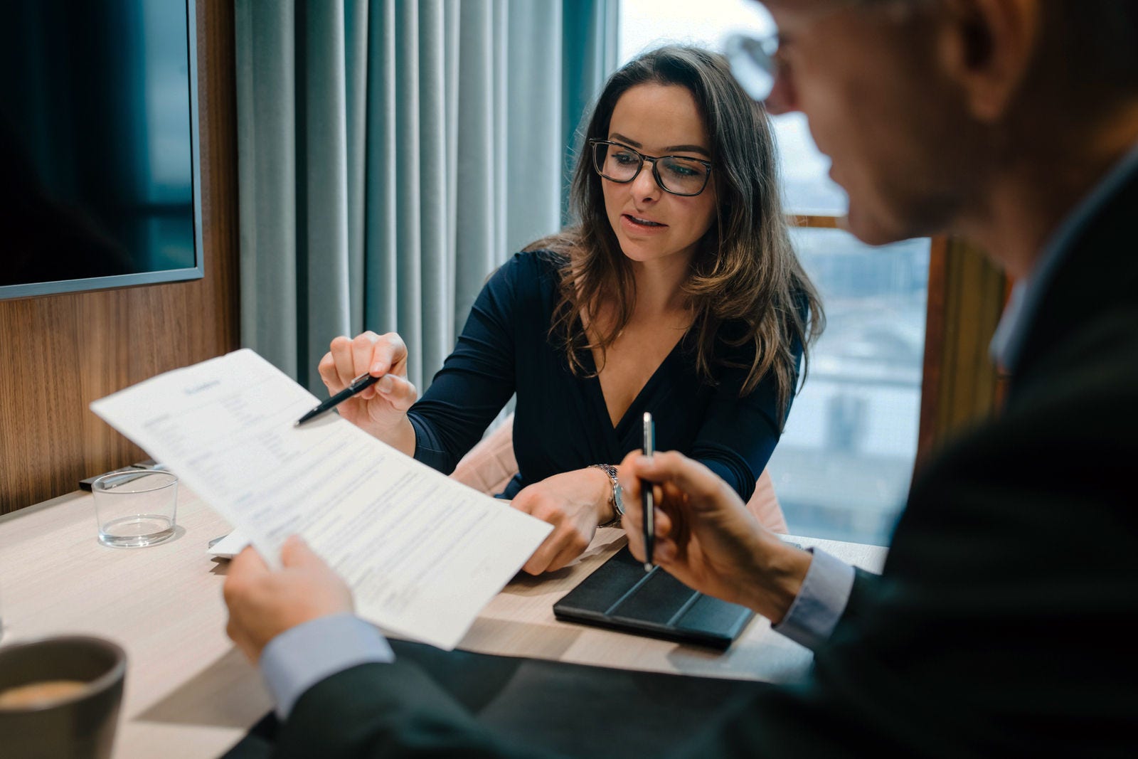 Male and female entrepreneur brainstorming over document during meeting in office