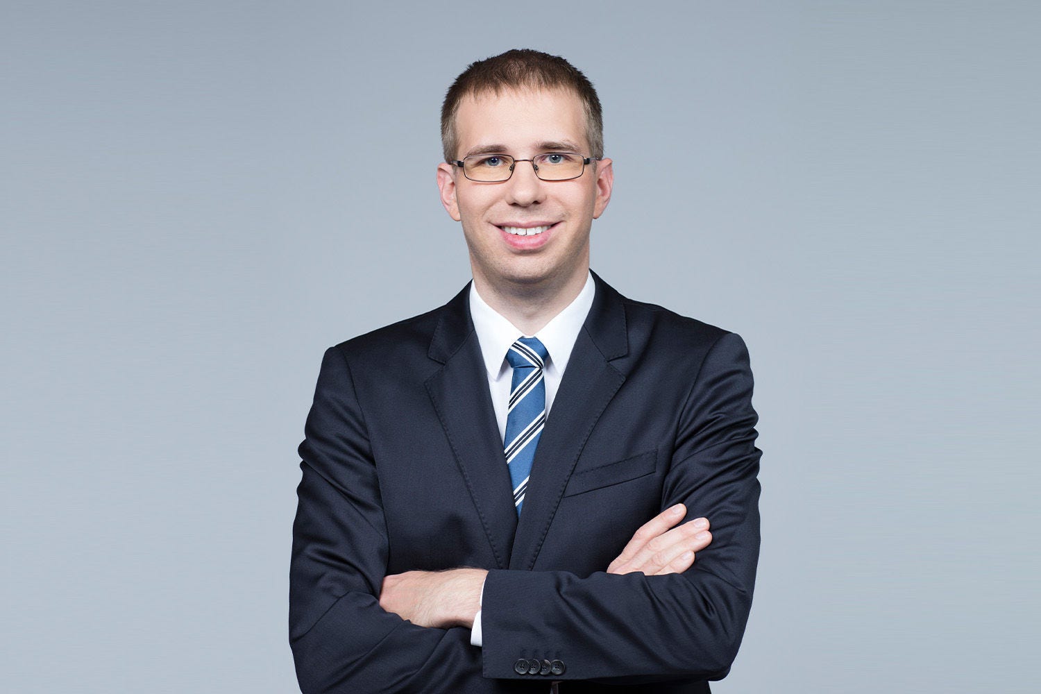 Porträt von Florian Brugger vor einem hellgrauen Hintergrund