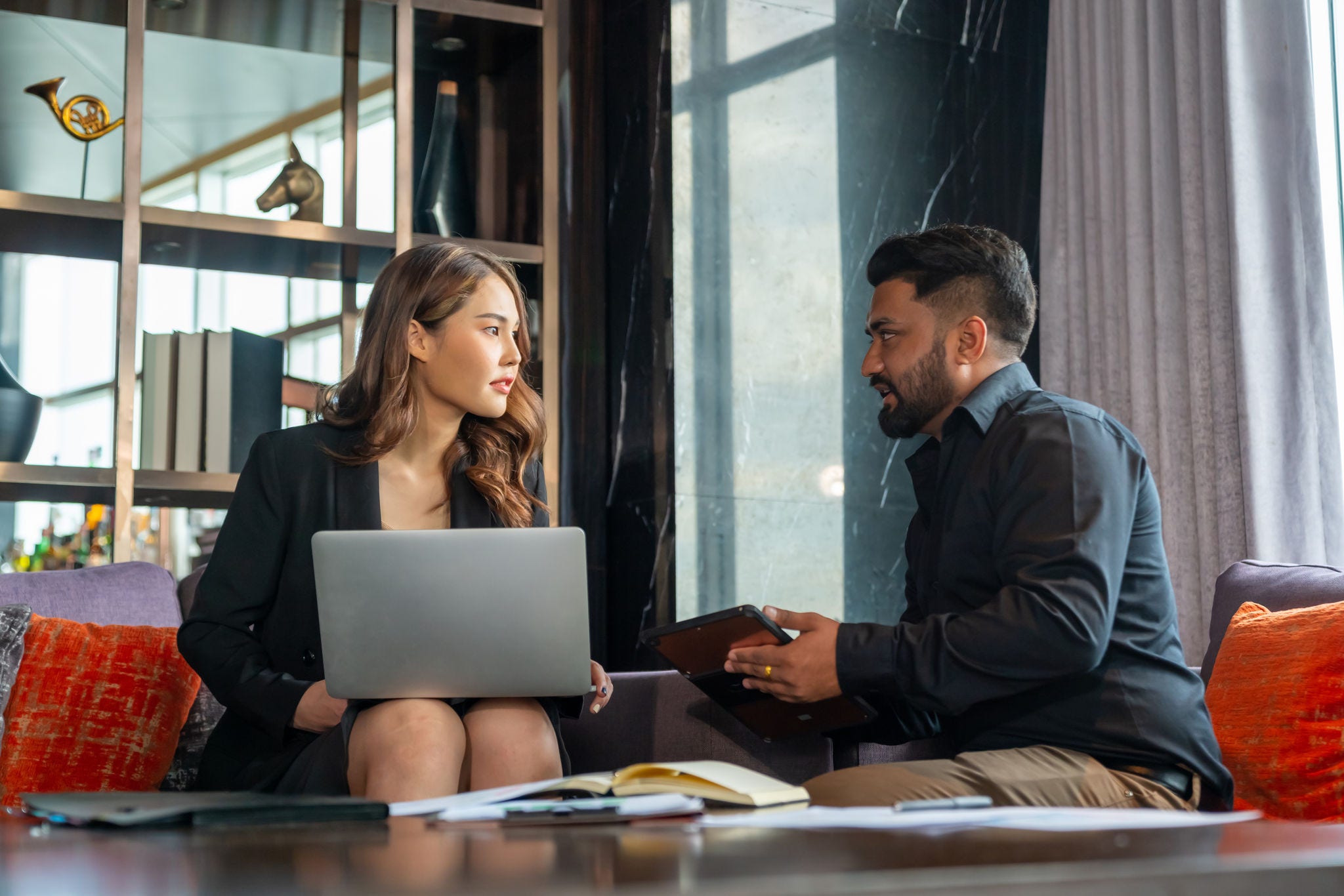 Businessman and businesswoman colleague using laptop and digital tablet working and discussion business plan at office building. Corporate business people partnership and teamwork meeting concept.