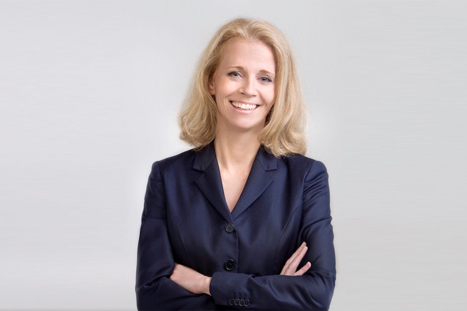 Porträt von Esther Freitag vor einer hellgrauen Wand