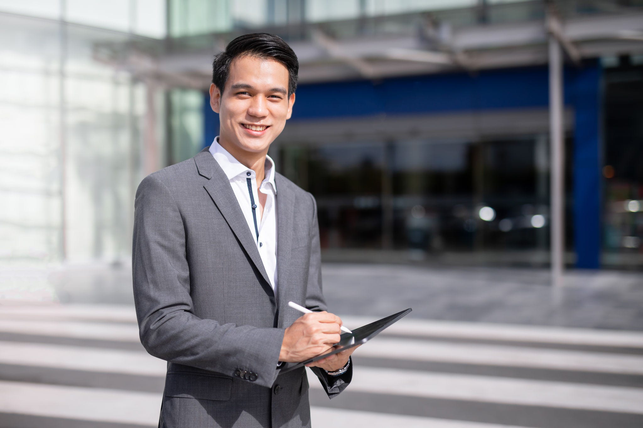 Young handsome business man holding tablet