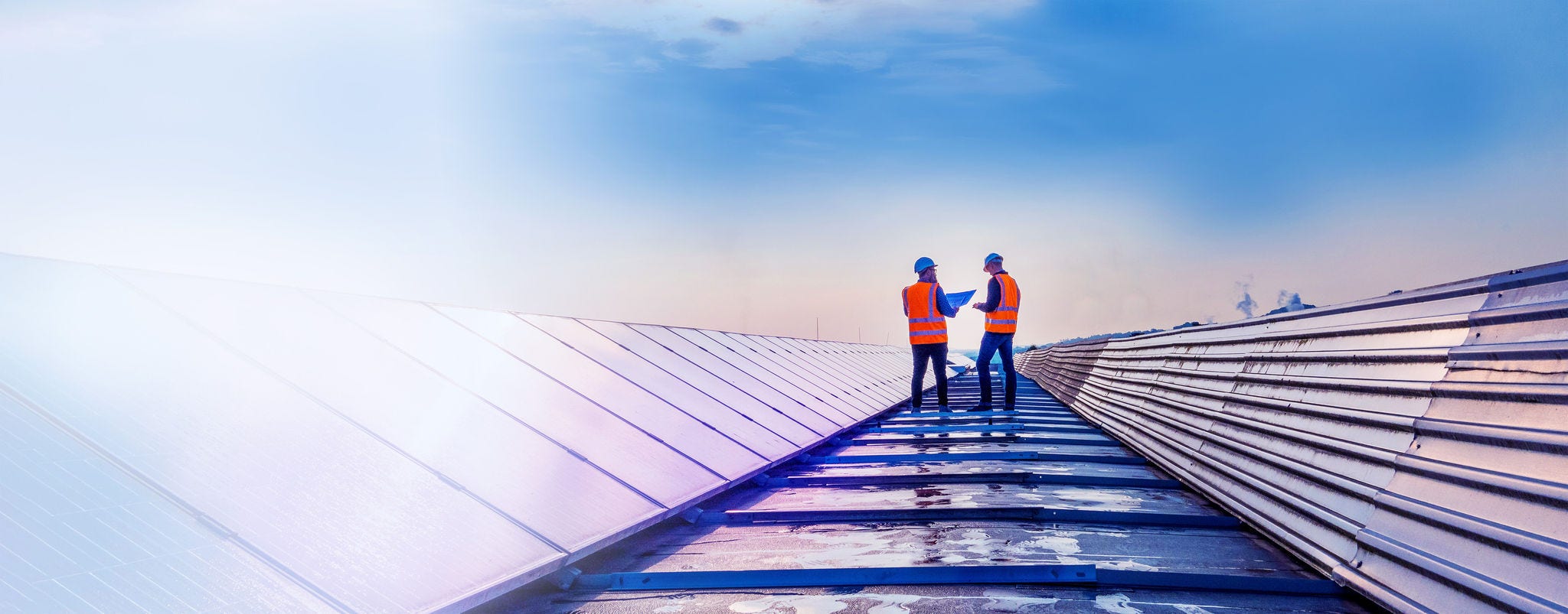 Two technicians assessing rooftop solar panels Two technicians assessing rooftop solar panels