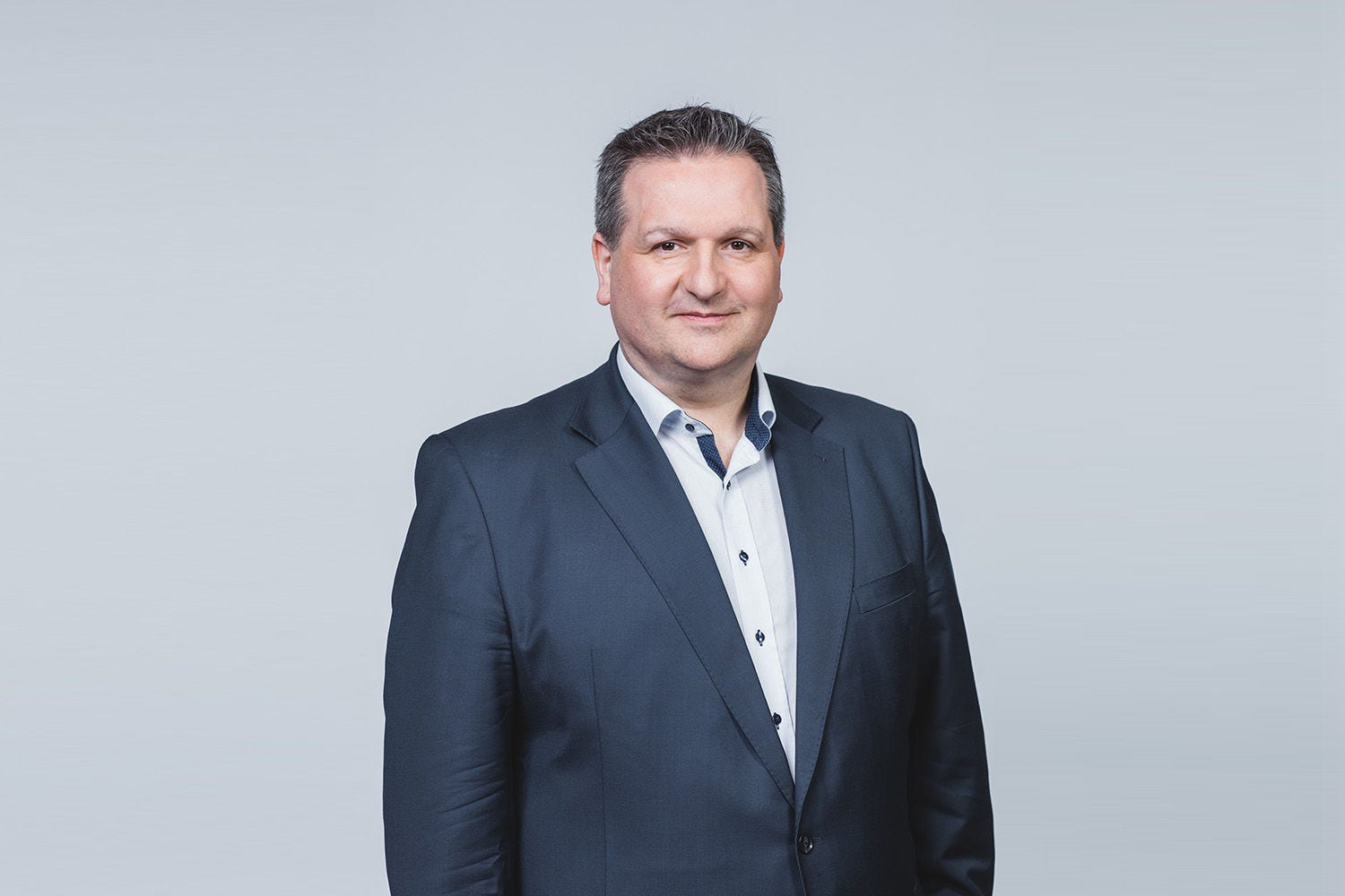 Porträt von Fritz Fraberger vor einem hellgrauen Hintergrund