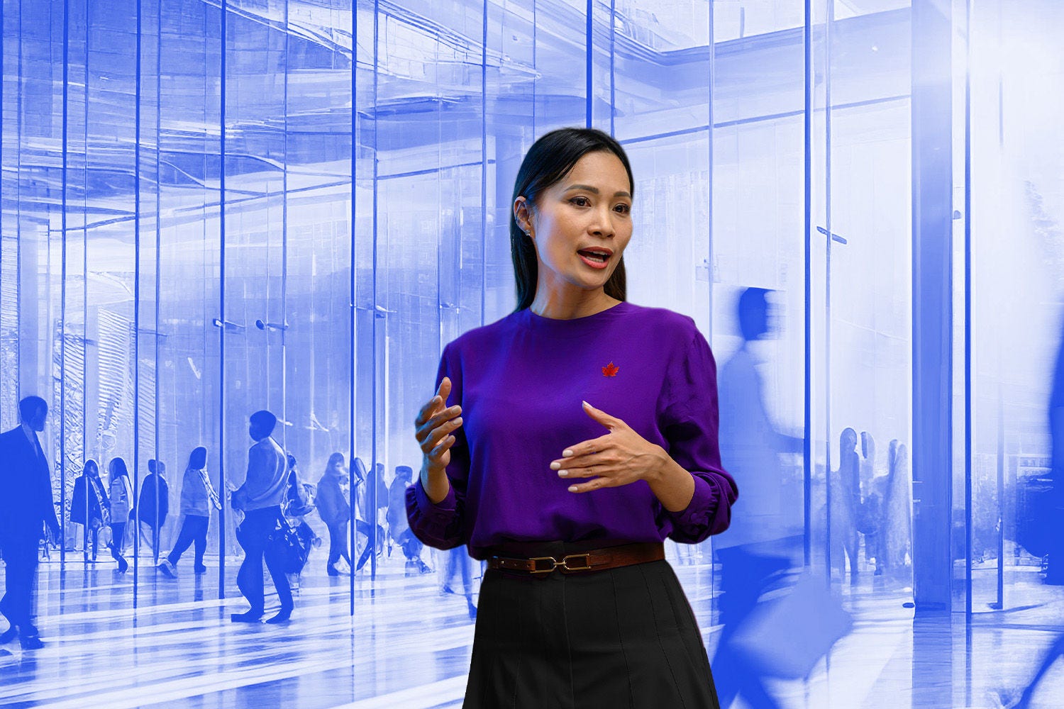 Woman in purple blouse talking with people walking in building lobby in the background