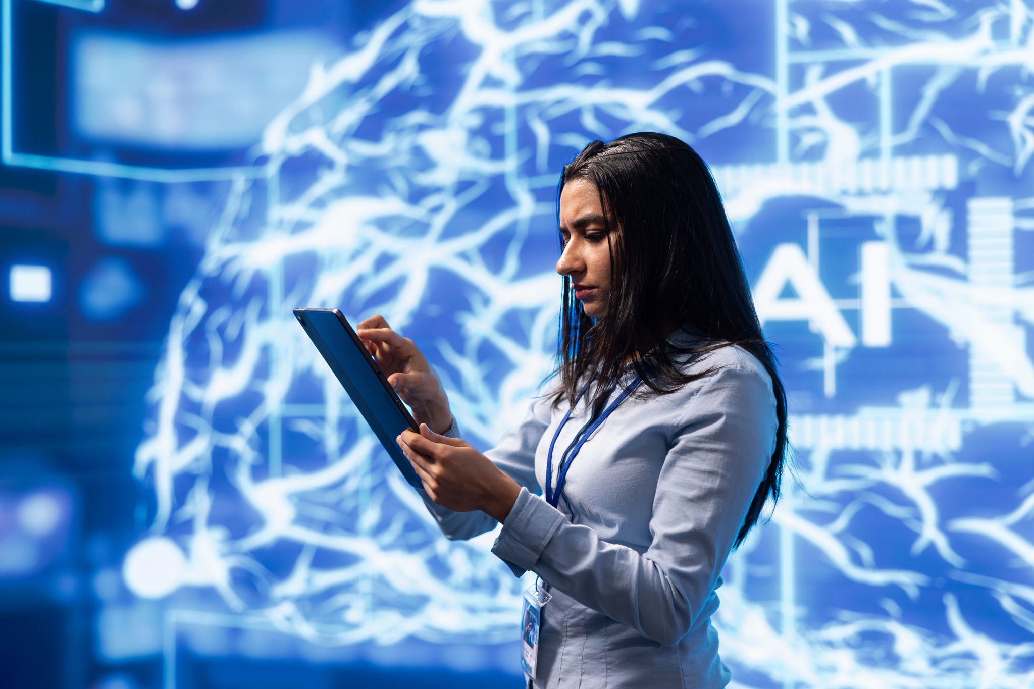 Computer scientist using artificial intelligence computing simulating human brain thought processes. Indian employee working on tablet, developing AI machine learning algorithms