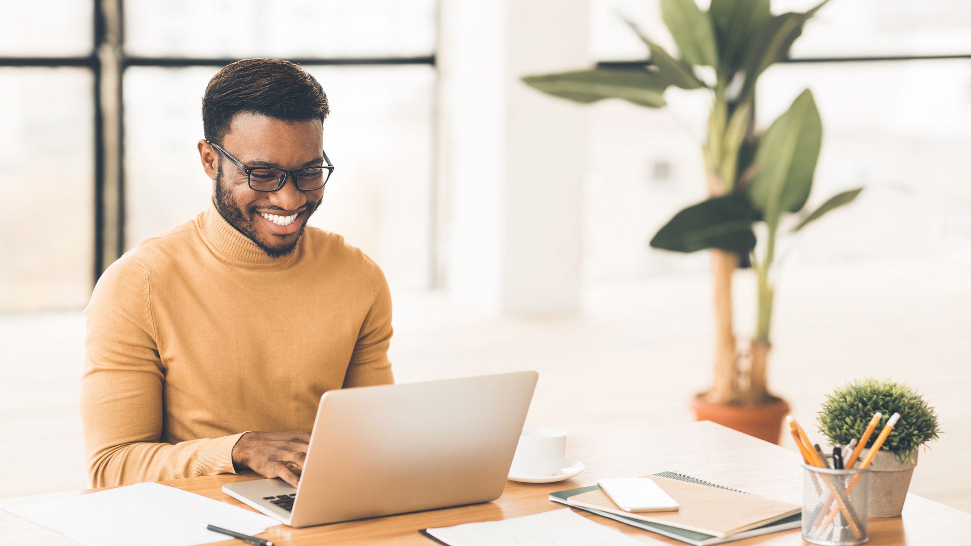 Man working on his laptop and smiling Man working on his laptop and smiling