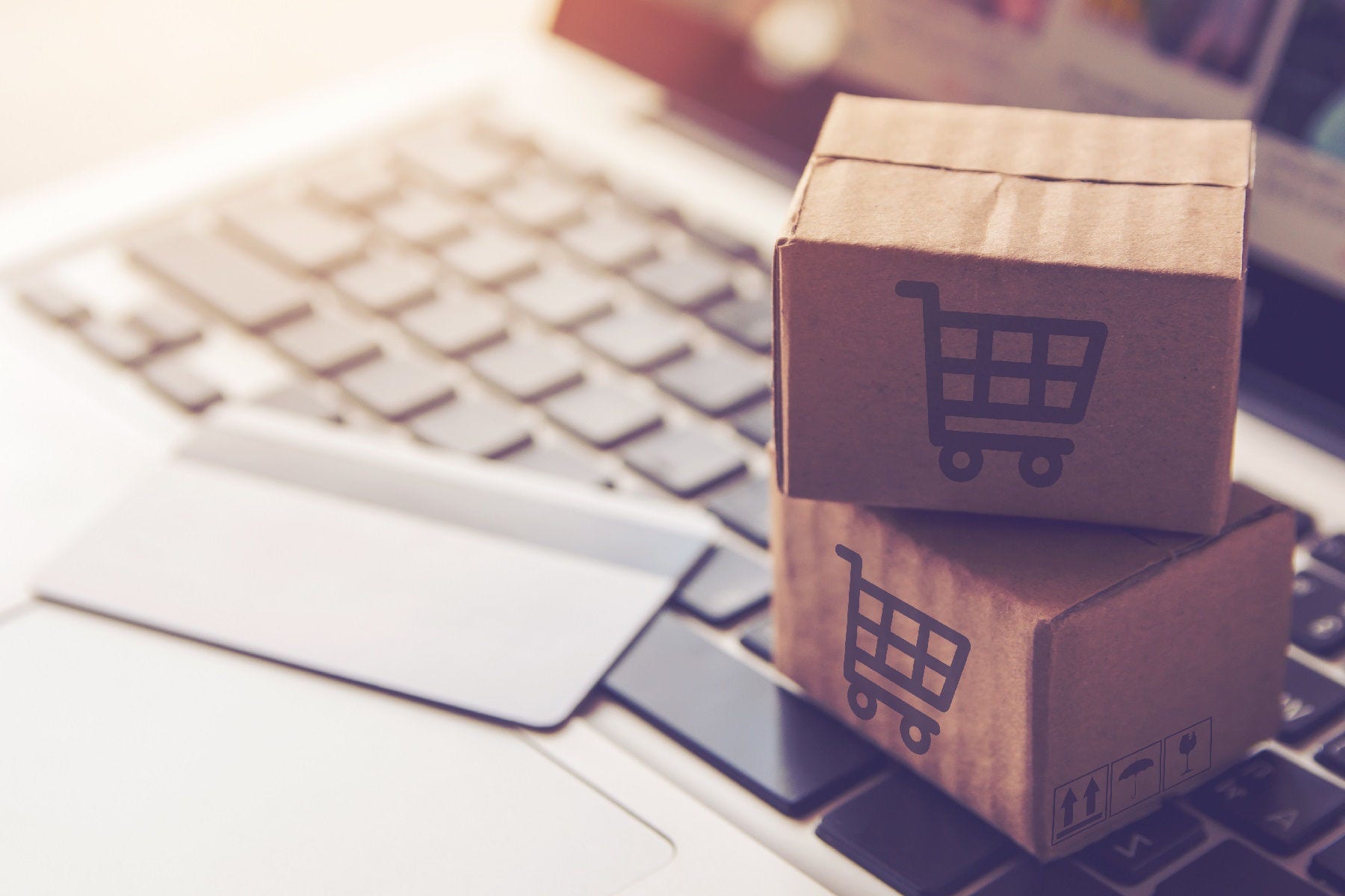 Shopping online concept - Shopping service on The online web. with payment by credit card and offers home delivery. parcel or Paper cartons with a shopping cart logo on a laptop keyboard