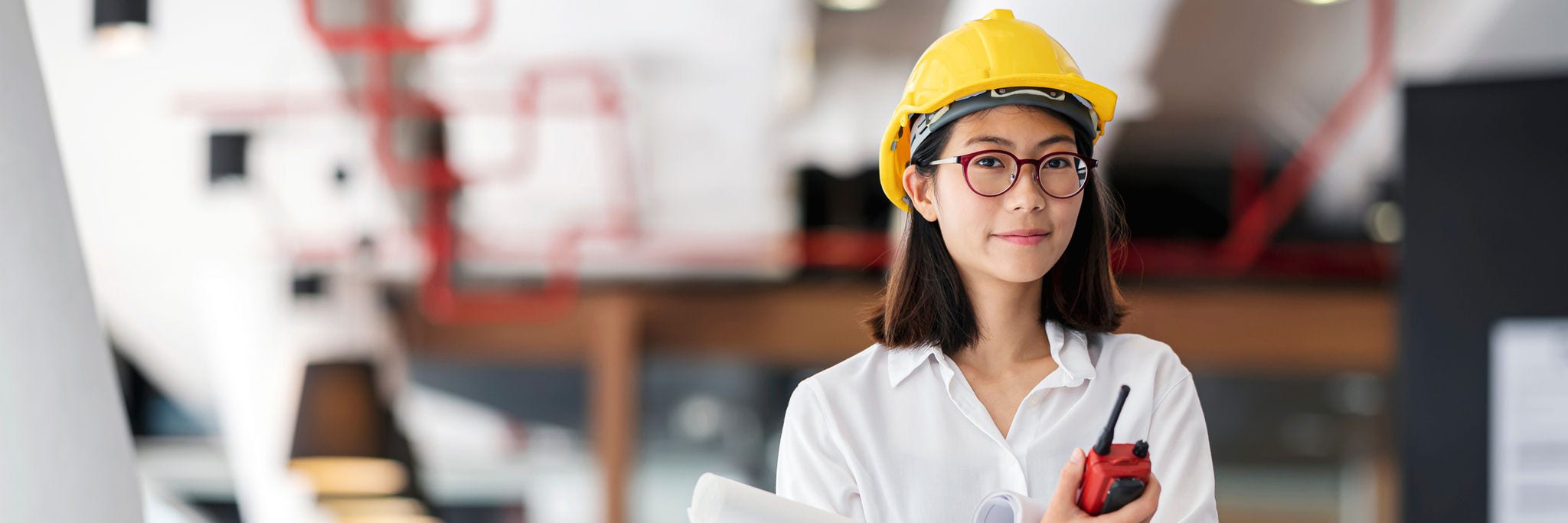 Beautiful female engineer standing in office.