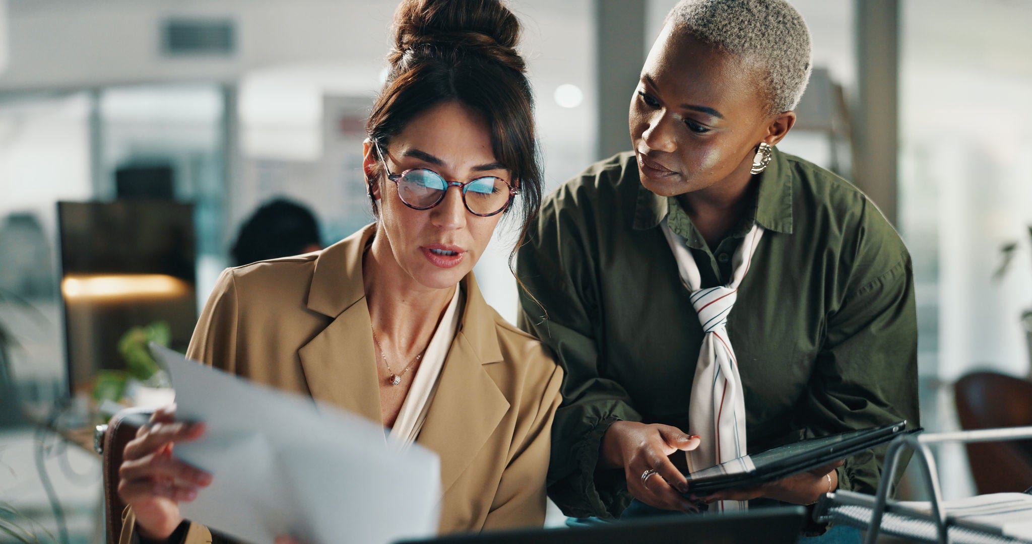 Women, tablet and team with documents in office for budget, review or report for project at finance company. Business people, tech and app with collaboration, feedback and asset management at agency