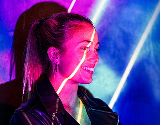Smiling woman with a beam of light across her face Smiling woman with a beam of light across her face