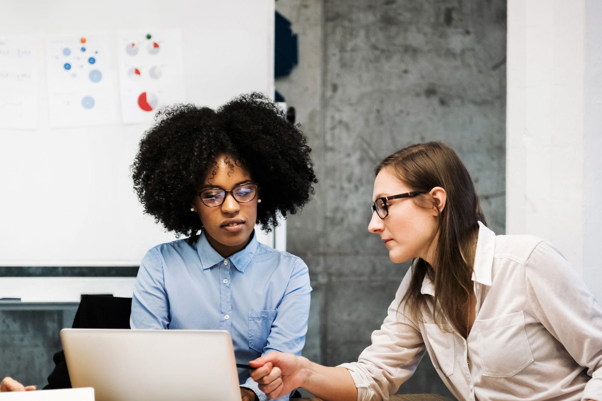 two women discussing over laptop