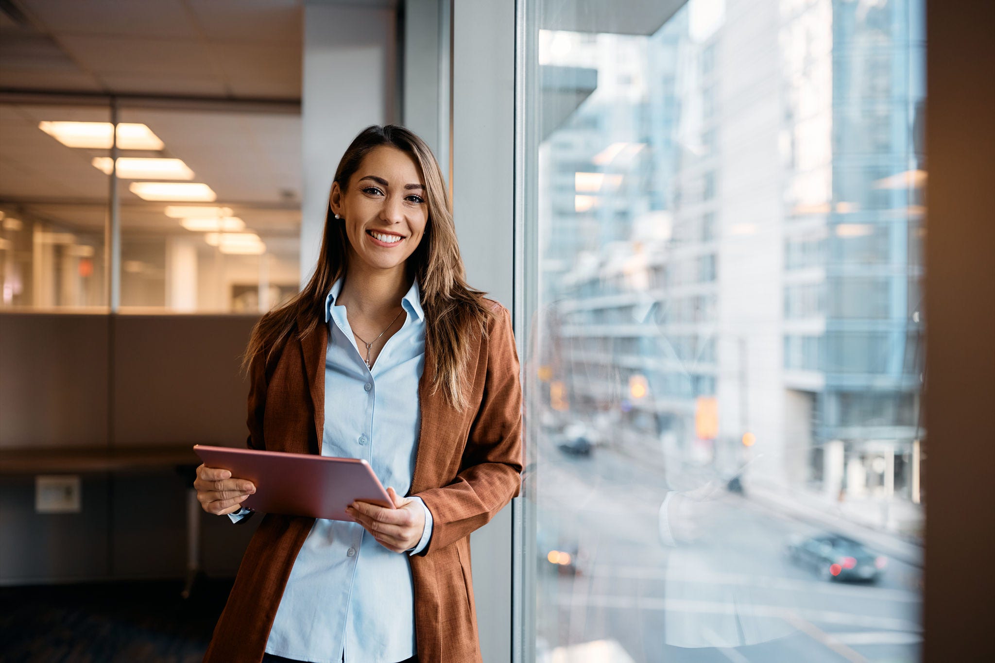 Portrait of happy businesswoman with touchpad in office looking at camera. Portrait of happy businesswoman with touchpad in office looking at camera.