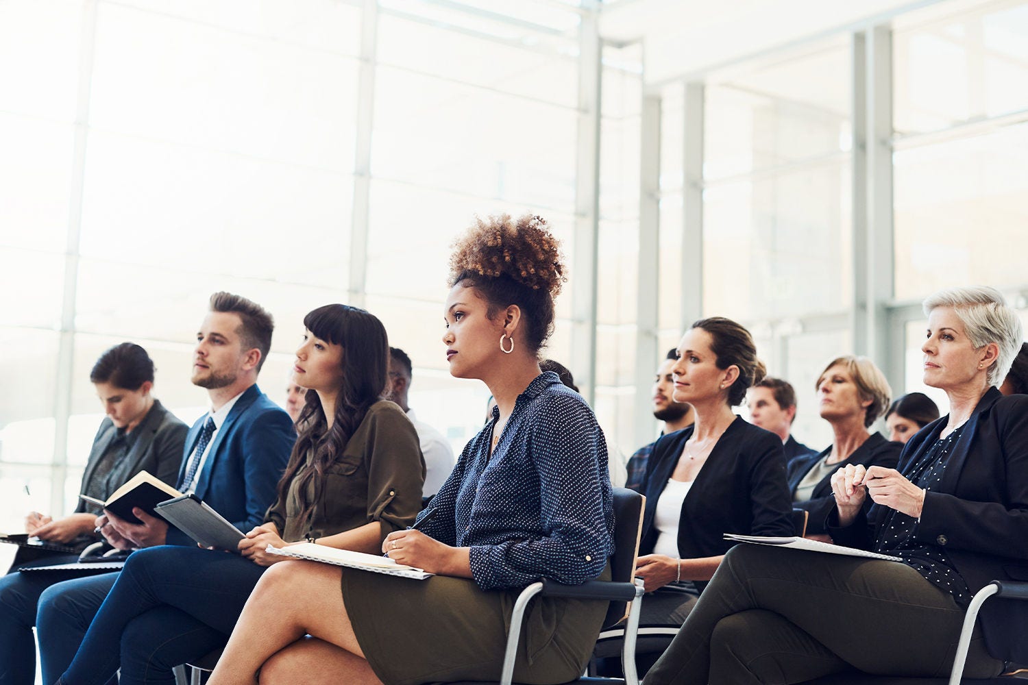 Business people seated at a conference, taking notes Business people seated at a conference, taking notes. Getty Images 1160947335