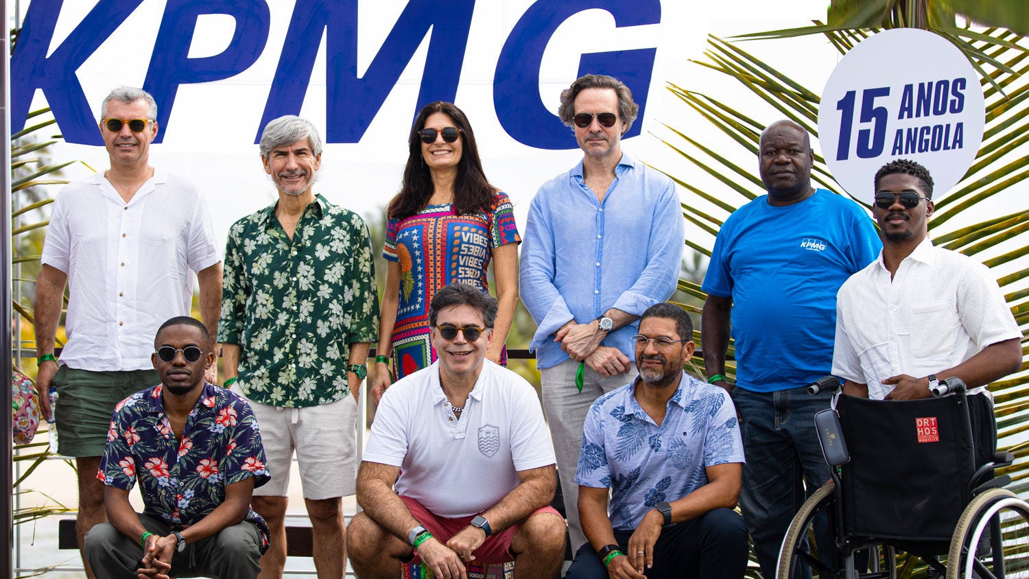 A group of KPMG employees posing for a commemorative photo marking KPMG’s 15th anniversary in Angola at an outdoor event