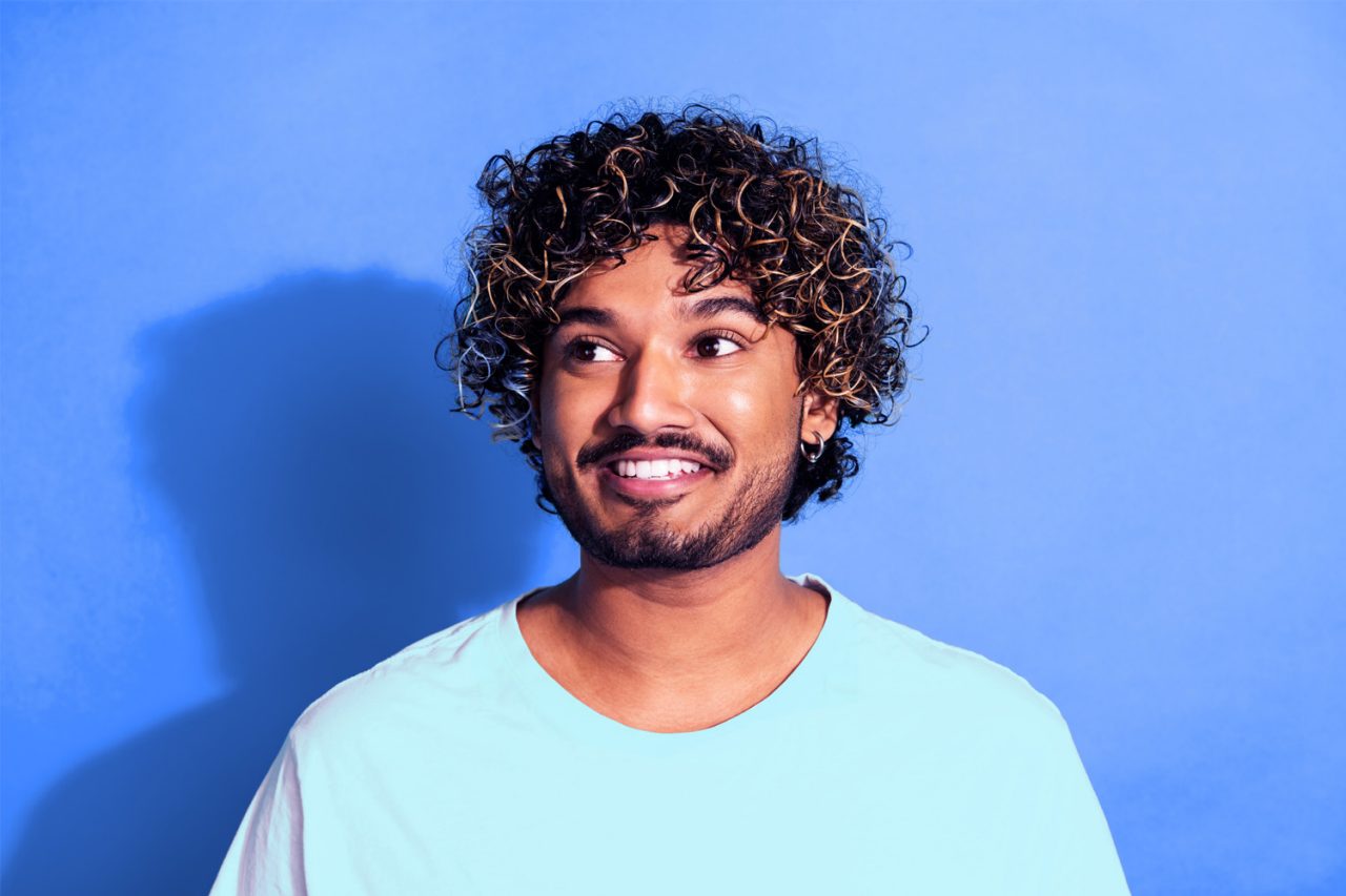 Grads careers pathways Consulting, Risk & ESG Curly hair boy on blue background