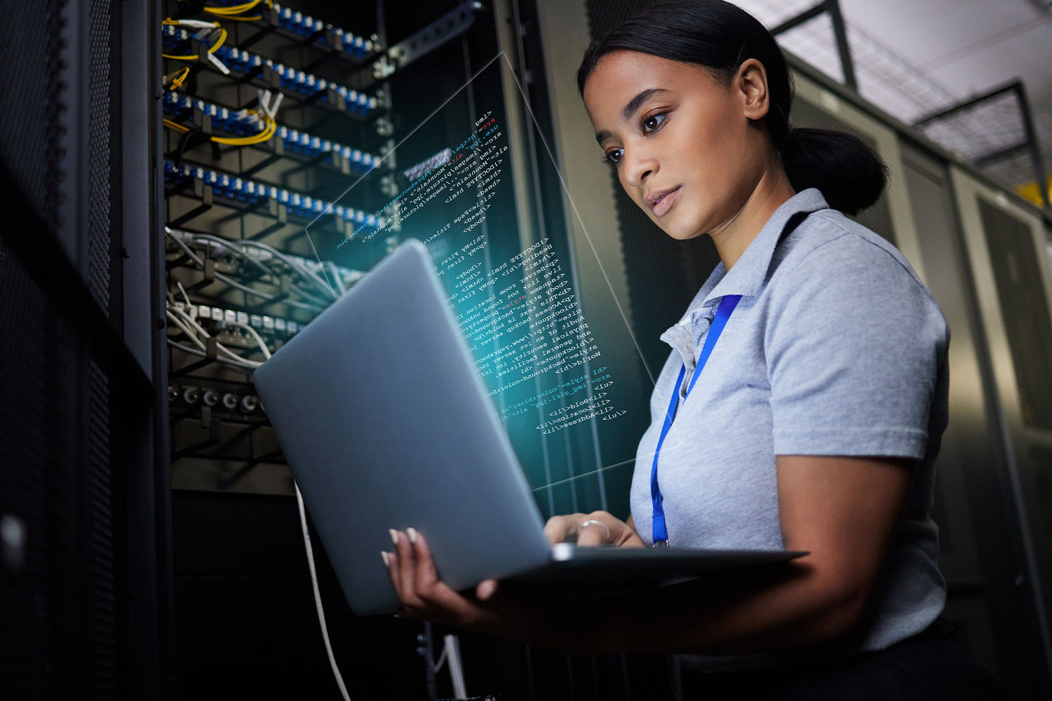 Professional using laptop in data center with servers and code overlay
