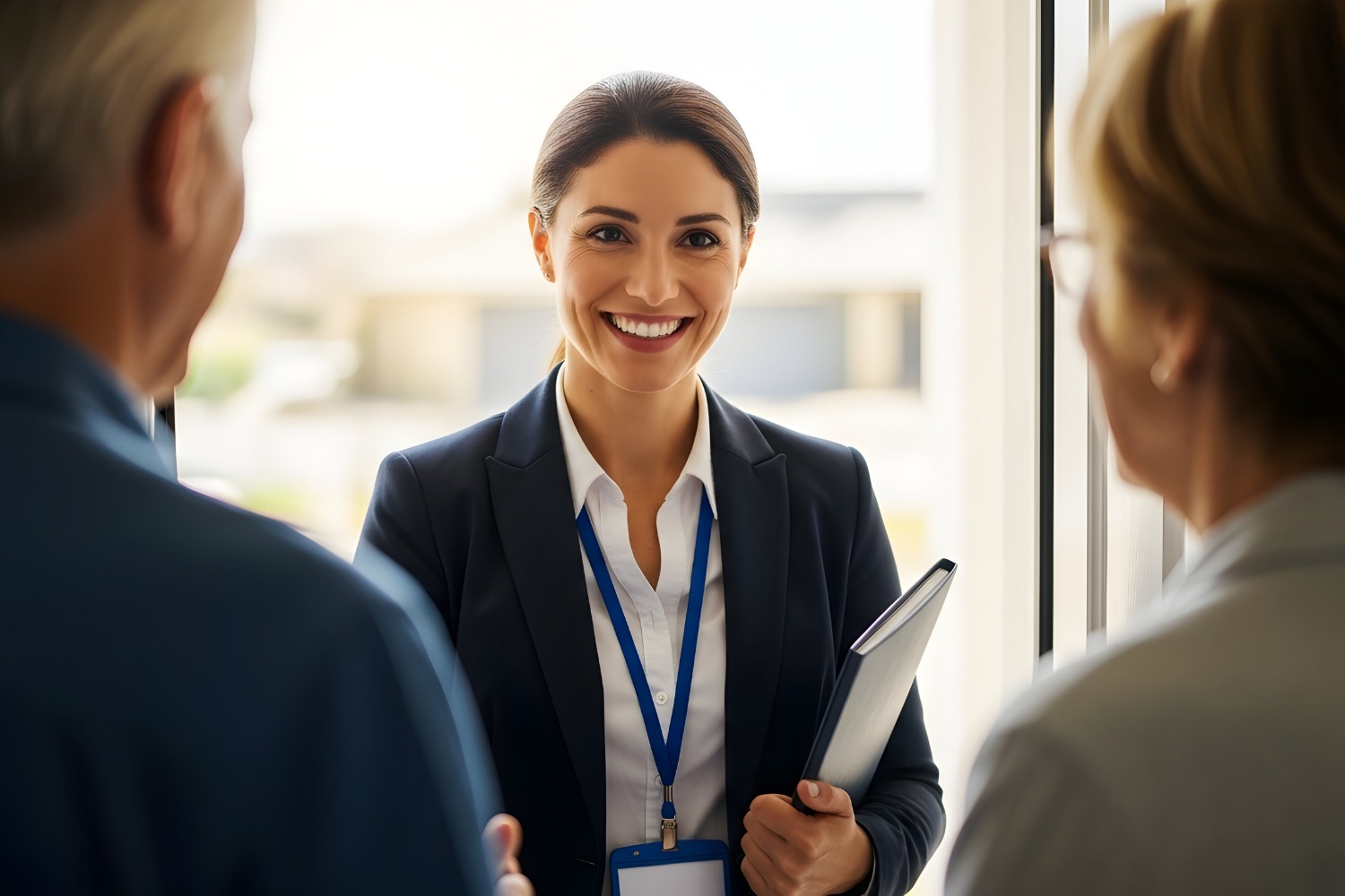 A person in a suit smiling looking at two other people